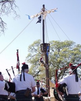 A mast rises on the horizon